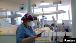 FILE - Nurse Eva Fiori updates a medical record of a patient suffering from the coronavirus disease (COVID-19) at the Intensive Care Unit (ICU) of Emilio Ribas Institute in Sao Paulo, Brazil, June 17, 2020. 