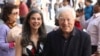 FILE - Arthur Frommer and his daughter, Pauline Frommer, pose among tourists in the Wall Street area in New York, May 20, 2012.