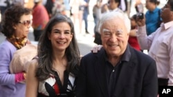 FILE - Arthur Frommer and his daughter, Pauline Frommer, pose among tourists in the Wall Street area in New York, May 20, 2012.