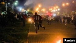 Los manifestantes corren en Bogotá, el 10 de mayo de 2021, luego de que las fuerzas policiales lanzaran gases lacrimógenos en una protesta contra el abuso policial, la pobreza y las deficiencias en el sistema sanitario en Colombia. 