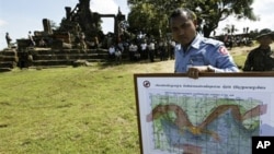 In this photo taken Nov. 7, 2008, a Cambodian deminer, holds a map of a disputed border at an entrance of Cambodia's Preah Vihear temple in a world heritage site near the Cambodian-Thai border.