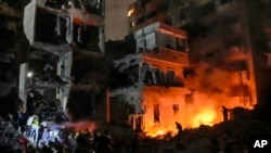 FILE - People gather near buildings hit by an Israeli airstrike in Beirut, Lebanon, Oct. 10, 2024. The U.S. Department of Homeland Security announced Thursday new guidelines offering temporary immigration protection that allow some Lebanese nationals to stay and work in the U.S. 