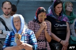 FILE - Faithful of the Ukrainian Orthodox Church, which is accused of having links with Russia, pray outside the historic Kyiv-Pechersk Lavra monastery, in Kyiv, July 4, 2023.