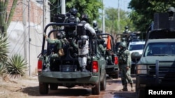 FILE - Federal forces guard the perimeter of a scene following a shootout where several suspected gang members were killed while one local cartel leader was arrested, on the outskirts of Culiacan, Sinaloa state, Mexico Oct. 22, 2024.