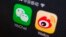 FILE - A picture illustration shows icons of WeChat and Weibo app in Beijing, Dec. 5, 2013. 