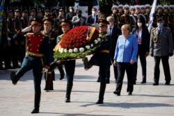 German Chancellor Angela Merkel takes part in a wreath-laying ceremony at the Tomb of the Unknown Soldier by the Kremlin Wall in central Moscow, Russia, Aug. 20, 2021.