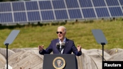 ARCHIVO - Se observan paneles solares al fondo mientras el presidente estadounidense Joe Biden habla durante una visita a Vernon Electric Cooperative en Westby, Wisconsin, EEUU, el 5 de septiembre de 2024.