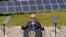 ARCHIVO - Se observan paneles solares al fondo mientras el presidente estadounidense Joe Biden habla durante una visita a Vernon Electric Cooperative en Westby, Wisconsin, EEUU, el 5 de septiembre de 2024.