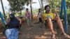 FILE - Indonesian children wearing face masks as a precaution against coronavirus outbreak play on swings in Jakarta, Indonesia, Sept. 23, 2020.