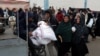 Палестинські чоловіки на інвалідному візку перевозять мішки з борошном від Агентством ООН з допомоги та організації робіт UNRWA, на тлі триваючого конфлікту між Ізраїлем і ХАМАСом, у Рафаху на півдні Сектора Гази 29 січня 2024 року.