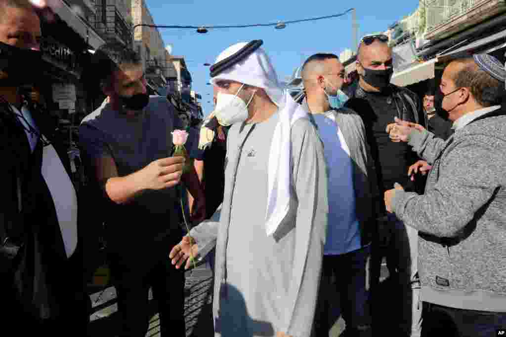 یک مرد اسرائیلی شاخه‌ای گل به ولید الجاسم، خواننده اهل امارات عربی متحده در جریان سفرش به اورشلیم تقدیم می‌کند