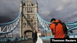 Tony Cao and Jenny Nguyen from Vietnam pose for wedding photos on the Tower Bridge, in London. Some daters insist on safety precautions before leaping into off-screen meetups. A lucky few are on the ultimate step, marriage.