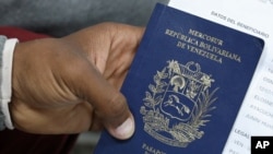 ARCHIVO - Migrante venezolano sostiene su pasaporte en una cola para obtener un permiso de residencia temporal fuera de la oficina de inmigración en Lima, Perú, 20 de agosto de 2018. REUTERS/Mariana Bazo