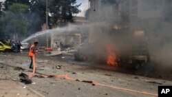 In this photo released by the Syrian official news agency SANA, Syrian citizens and firefighters gather at the scene where one of rockets hit the Dubeet hospital in the central neighborhood of Muhafaza in Aleppo, May 3, 2016.