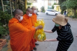 Sitanun Satsaksit, sister of the missing Thai activist Wanchalearm Satsaksit, holds a religious ceremony in front of the condominium where he disappeared in Phnom Penh, Cambodia, Dec. 4, 2020. (Reuters)