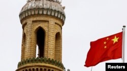 Un drapeau national chinois flotte près d'un minaret de l'ancienne mosquée Id Kah dans la vieille ville de Kashgar, dans la région autonome ouïgoure du Xinjiang, en Chine, le 6 septembre 2018. Photo prise le 6 septembre 2018.