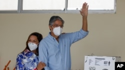 Guillermo Lasso, ahora presidente electo de Ecuador, saluda después de votar acompañado de su esposa, María de Lourdes Alcívar, durante una segunda vuelta de las elecciones presidenciales en Guayaquil. Marzo 11, 2021. Foto: AP.