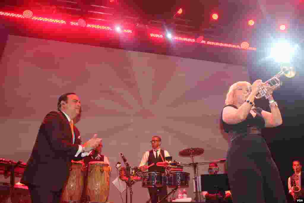 El cantante puertorriqueño Gilberto Santa Rosa disfruta de la interpretación de una integrante de su orquesta a ritmo de trompeta.