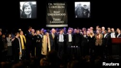 Participants link arms during an interfaith memorial service at the Jewish Community Center of Greater Kansas City in Overland Park, Kansas April 17, 2014.