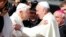 Pope Francis, right, greets Emeritus Pope Benedict XVI before a mass in Saint Peter's square at the Vatican, Sept. 28, 2014. 