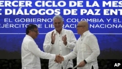 El presidente de Cuba, Miguel Díaz-Canel, aplaude mientras el presidente de Colombia, Gustavo Petro (izq) y el comandante del ELN, Antonio García, se dan la mano durante la firma del alto al fuego bilateral entre el gobierno y la guerrilla, en La Habana, el 9 de junio de 2023.