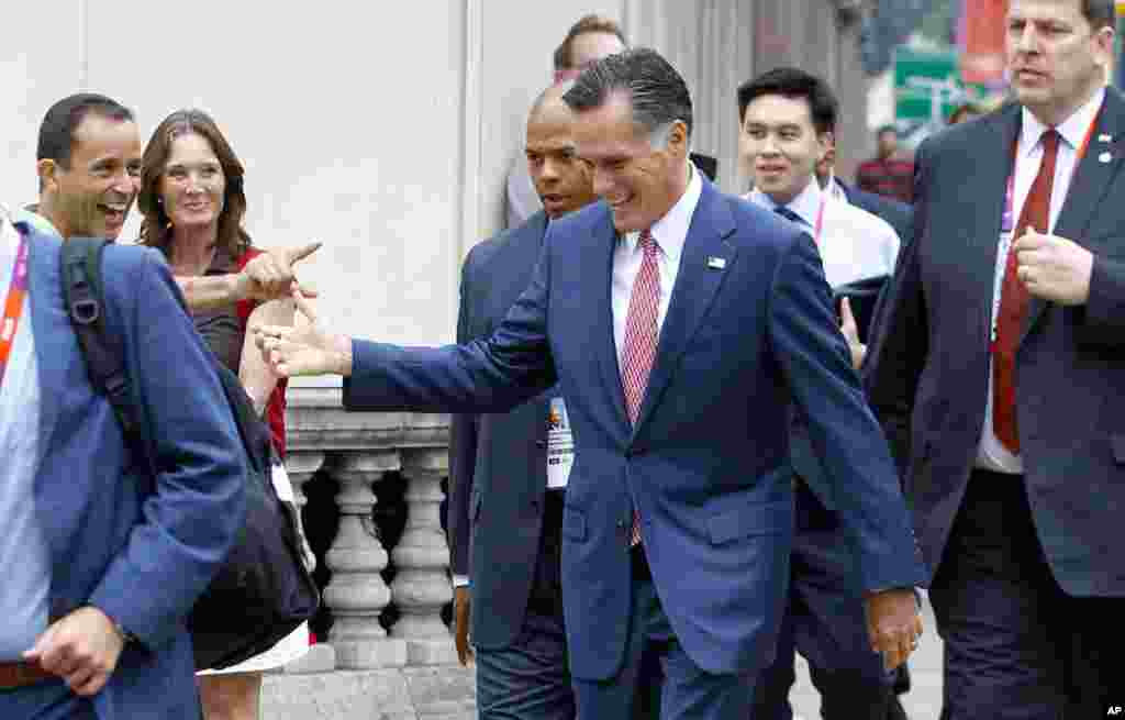 Romney walks down Grosvenor Place to avoid a traffic jam and is recognized by bystanders. He was walking to meet Ireland's Prime Minister Enda Kenny at the Embassy of Ireland in London, Britain, July 27, 2012.