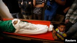 Palestinski dečak kraj tela supruge i deteta lidera Hamasa Mohameda Deifa tokom sahrane