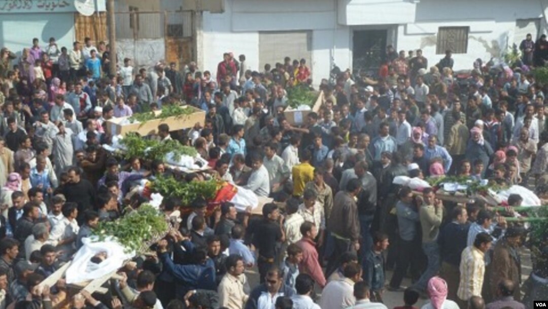 Para demonstran anti-pemerintah menggotong jenazah seorang di antara mereka yang tewas di Hula, dekat Homs, Rabu (2/11).