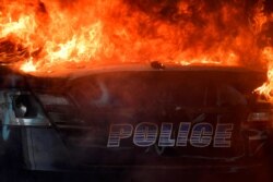 FILE - An Atlanta Police Department vehicle burns during a demonstration against police violence, May 29, 2020 in Atlanta.