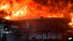 An Atlanta Police Department vehicle burns during a demonstration against police violence, May 29, 2020 in Atlanta. 