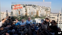 Israeli Minister of Housing and Construction Uri Ariel (C) speaks to journalists during a ceremony to mark the resumption of the construction of housing units in an east Jerusalem neighborhood, August 11, 2013.