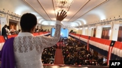 Une femme prie lors d'un service religieux au pavillon commémoratif du centenaire à Monrovia le 21 janvier 2018, la veille de l'investiture du nouveau président.