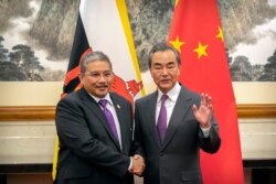 Chinese Foreign Minister Wang Yi, right, shakes hands with Brunei's Second Minister of Foreign Affairs and Trade Erywan Yusof as he arrives for a meeting at the Diaoyutai State Guesthouse in Beijing, Jan. 21, 2020.