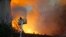 A firefighter uses a hose as Notre Dame cathedral is burning in Paris, April 15, 2019.