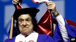 FILE - In this May 29, 2010, file photo, author Richard Goodwin receives a Doctor of Humane Letters honorary degree from Trustee Edward Collins during commencement ceremonies at UMass-Lowell at the Tsongas Center in Lowell, Mass. 