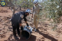 FILE - Syrian Civil Defense group inspects cluster bombs in the Khan Sheikhoun neighborhood of Idlib, Syria, Sept. 29, 2016.