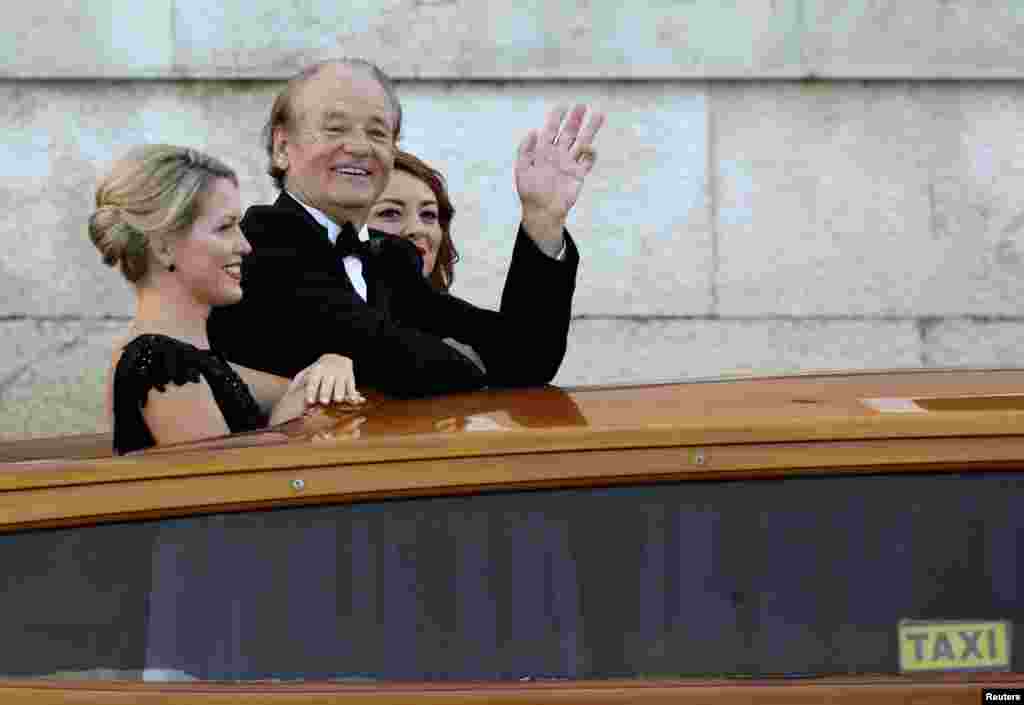 U.S. actor Bill Murray waves as he boards a taxi boat transporting guests to the venue of a gala dinner ahead of the official wedding ceremony of George Clooney and his fiancee Amal Alamuddin in Venice, Sept. 27, 2014. 