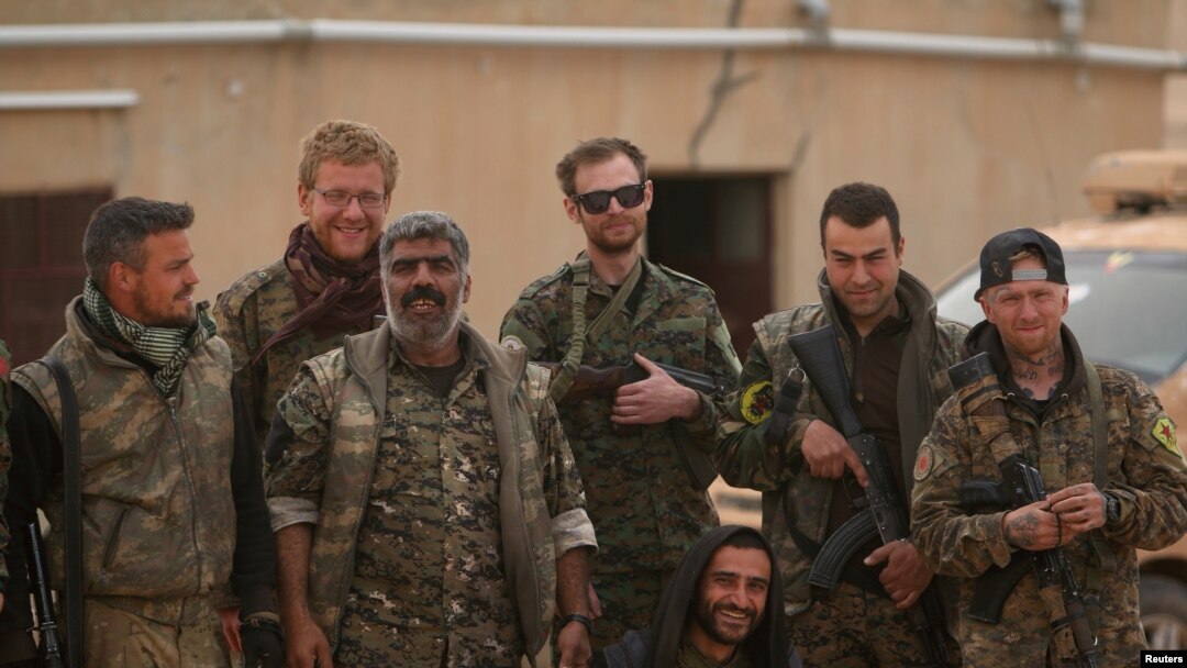 Pasukan Angkatan Darat Suriah (SDF) berpose dengan pejuang relawan asing di bandara militer Tabqa di Raqqa, Suriah, setelah merebutnya dari ISIS, 9 April 2017. (Foto: dok).