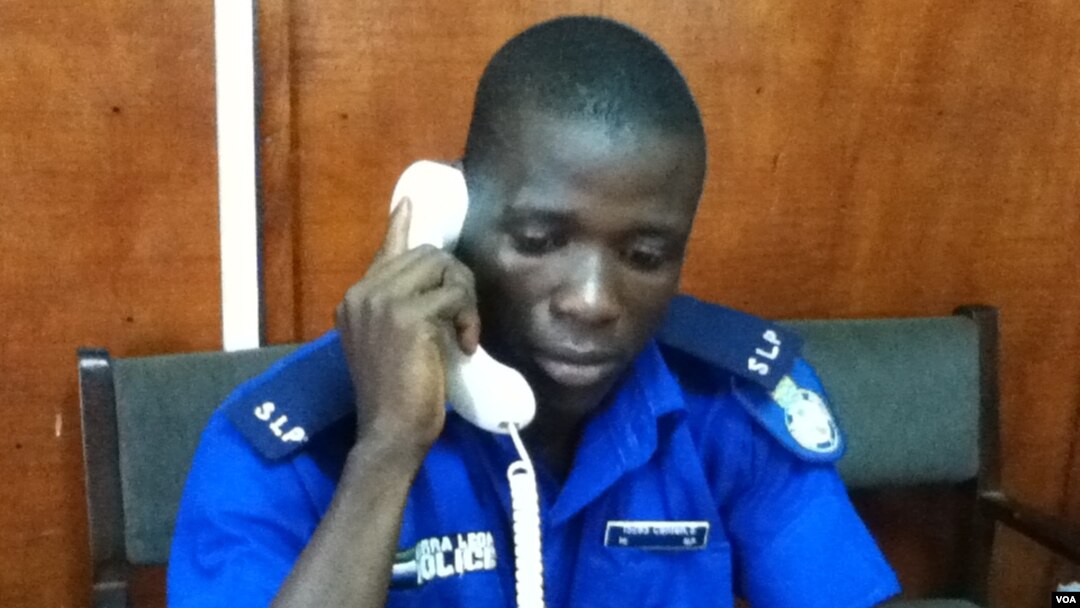 Sheka Conteh answers phones at the police call centre, Freetown, February 1, 2013. (N. de Vries/VOA)