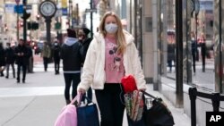 En esta fotografía de archivo del 10 de diciembre de 2020, una mujer carga bolsas de compras en Nueva York.