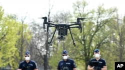 Police officers prepare a drone to find residents who fail to comply with the stay-at-home order implemented due to the coronavirus pandemic in Szolnok, Hungary, April 13, 2020.