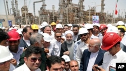 FILE - Iranian President Hassan Rouhani, center, inaugurates the Persian Gulf Star Refinery in Bandar Abbas, Iran, April 30, 2017.