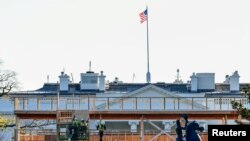 Para pekerja membangun panggung untuk penonton di depan Gedung Putih menjelang upacara pelatikan presiden, di Washington D.C, 28 November 2020. (Foto: Reuters)