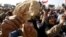 An Egyptian holds a piece of bread to protest against the high prices of goods in Tahrir square in Cairo, Feb. 8, 2013.