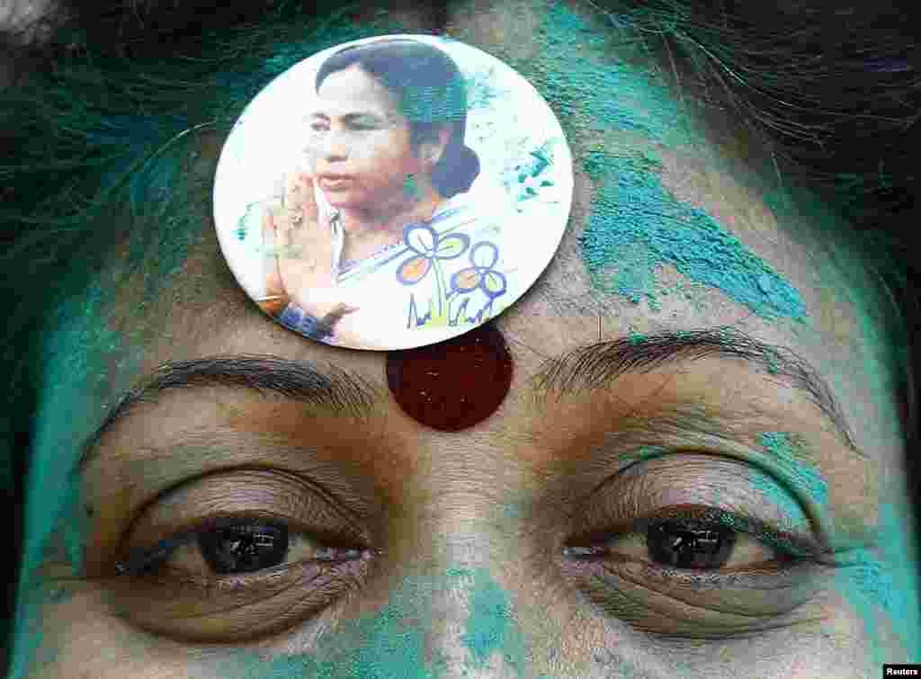 A supporter of Mamata Banerjee, chief minister of the eastern Indian state of West Bengal and Trinamool Congress (TMC) , wears her picture during the celebrations after learning of the early poll results in Kolkata, May 16, 2014.