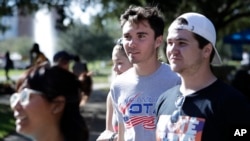 En esta foto del miércoles 31 de octubre de 2018, David Hogg (centro), un estudiante que sobrevivió la matanza en la escuela secundaria Stoneman Douglas camina con voluntarios a un punto de encuestas en el campus de la Universidad de Central Florida en Orlando, durante un evento de Vote for Our Lives. Nueve meses después que 17 compañeros y profesores fueron asesinados en su escuela, los estudiantes de Parkland finalmente llegan al momento que esperaban, su primer día de elecciones, con marchas, protestas pacíficas y eventos de registro de votantes en todo el país. AP/John Raoux.