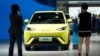 People use their phones in front of the BYD Seagull that is displayed at the Auto Shanghai show, in Shanghai, China April 19, 2023.