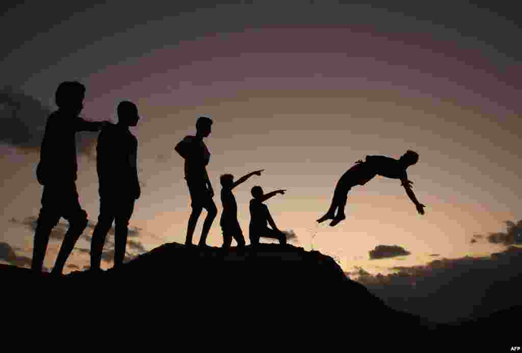 Palestinian youths practice parkour at sunset in Gaza City.