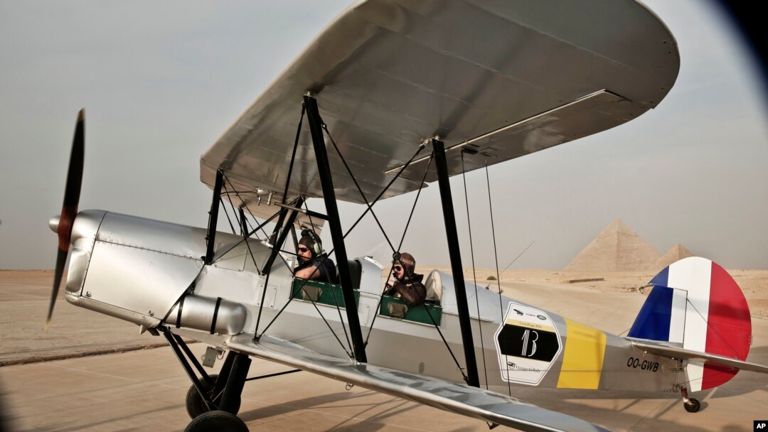 FILE - A vintage airplane lands during a rally across Africa, at the Giza Pyramids in Egypt, Nov. 13, 2016.