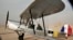 FILE - A vintage airplane lands during a rally across Africa, at the Giza Pyramids in Egypt, Nov. 13, 2016.